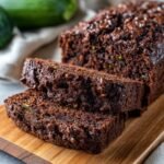 Close-up of two slices of moist Double Chocolate Zucchini Bread, studded with chocolate chips.