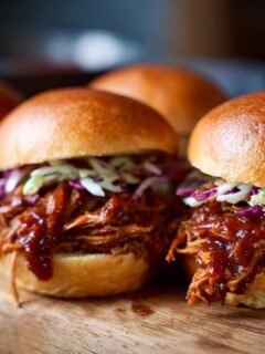 Close-up of a Flavorful BBQ Pulled Pork Sliders party favorite, with tender pulled pork and coleslaw on a bun.