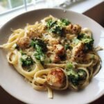 A close-up of Flavorful Chicken and Broccoli Alfredo Pasta on a white plate, with creamy sauce, tender chicken, and vibrant broccoli florets.