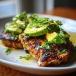 Close-up of Grilled California Avocado Chicken topped with fresh avocado slices and cilantro.
