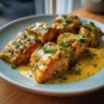 Close-up of Irresistible Bang Bang Salmon fillets coated in a creamy sauce and sprinkled with fresh parsley.