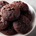 A close-up of a pile of Irresistible Chocolate Zucchini Cookies, studded with chocolate chips.