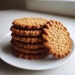A stack of Irresistible Breakfast Protein Biscuits on a white plate, perfect for an energizing start.