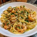 A close-up of Irresistible Shrimp Scampi Garlic Lemon Delight served over linguine pasta, garnished with parsley and red pepper flakes.