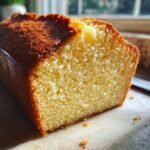 Close-up of a slice of Ms. Johnny Ruth Pound Cake, showing its golden-brown crust and tender crumb.
