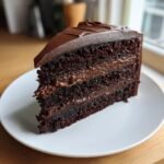 A rich slice of Nestle Toll House Death by Chocolate Cake with layers of dark chocolate cake and frosting.