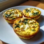 Three delicious Quick Healthy Egg Muffins with Spinach and Feta on a white plate, ready to eat.
