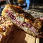 A slice of Savory Ham and Gruyère Cake, showing layers of ham and melted cheese between toasted bread.