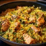 Close-up of a Zesty Lemon Salmon Orzo Skillet, featuring flaky salmon pieces and orzo pasta with fresh parsley and lemon zest.