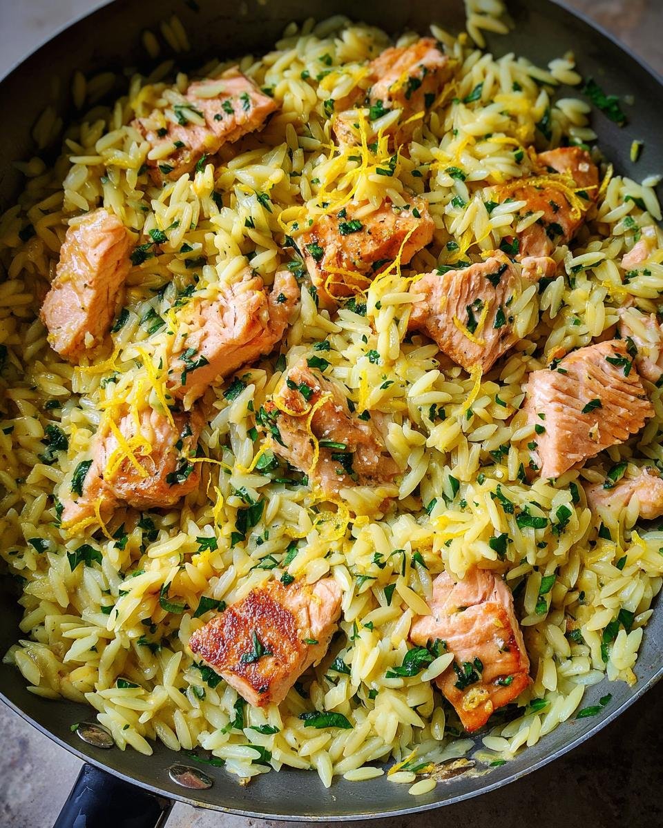 Close-up of a Zesty Lemon Salmon Orzo Skillet Recipe with flaky salmon pieces and bright lemon zest.