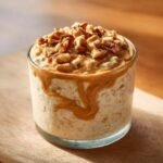 A glass jar filled with Delicious Peanut Butter Banana Overnight Oats, topped with peanut butter drizzle and chopped walnuts.