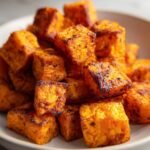 Close-up of Irresistible Air Fryer Sweet Potatoes, perfectly crispy and fluffy, piled in a bowl.