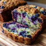 Close-up of sliced Irresistible Blueberry Lemon Zucchini Bread, showing juicy blueberries and green zucchini shreds.