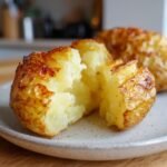 Close-up of Irresistible Crockpot Baked Potatoes, split open to reveal fluffy interior.