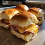 Close-up of Irresistible Ham and Cheese Sliders on soft Hawaiian rolls, with melted cheese and savory ham.