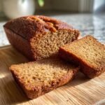 Close-up of Irresistible Moist Zucchini Bread, with two slices cut and placed on a wooden board.