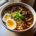 A close-up of a bowl of savory Beef Ramen featuring tender beef slices, ramen noodles, mushrooms, and a soft-boiled egg.