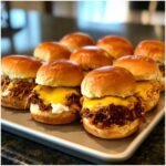 A tray of delicious pulled pork sliders topped with melted cheese, perfect for parties.