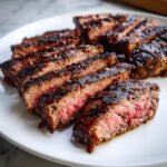 Close-up of perfectly grilled and sliced Churrasco Steak showing a juicy, medium-rare interior and dark sear.