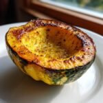 Close-up of a single half of Roasted Acorn Squash, showing caramelized edges and glistening interior.