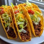 Three fully loaded, crispy shell Baked Tacos filled with seasoned ground beef, shredded lettuce, cheese, and salsa.