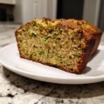 A close-up cross-section of moist Zucchini Bread With Apples showing shredded zucchini and apple chunks.
