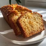 Close-up of a loaf of Pineapple Quick Bread, sliced to show the moist, golden crumb with visible fruit pieces.