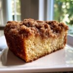 Close-up of a moist slice of Starbucks Coffee Cake featuring a thick, sugary cinnamon crumb topping.