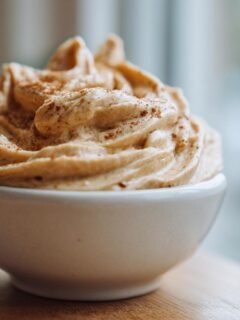 Close-up of creamy, whipped Monkey Butter topped with a sprinkle of cinnamon, served in a small white bowl.