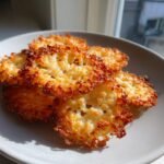 Close-up of crispy, lacy Parmesan Crisps piled on a light gray plate, perfectly browned.