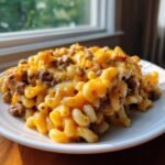 Close-up of a serving of Cheesy Ground Beef Pasta Skillet topped with melted cheddar cheese.