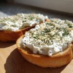 Two slices of toasted bread topped generously with creamy cottage cheese and sprinkled with herbs for Cottage Cheese Breakfast Toast.