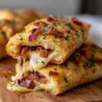 Close-up of Ooey Gooey Garlic Butter Bacon Ranch Pizza Rolls split open showing melted cheese stretching between the two halves.