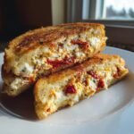 Two halves of golden brown Sun Dried Tomato And Feta Stuffed French Toast showing creamy filling.